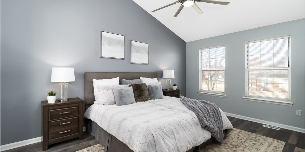 Master bedroom of staged home in St. Charles, MO, highlighting pillows in neutral colors