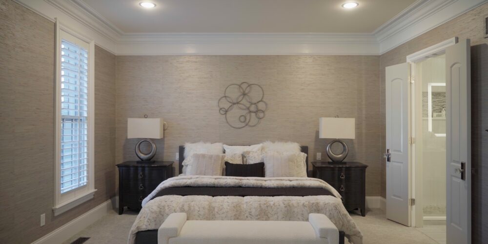 Still 2025-10-20 181133_1.11.1 Master bedroom of a home in Clayton, MO. The room is staged with matching end tables, lamps, and decorative pillows in white and black to match the room's tones.