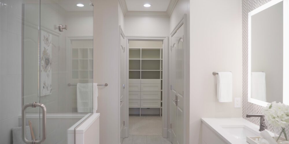 Still 2025-10-20 181133_1.13.1 The master bathroom of a home in Clayton, MO. It has been professionally staged and features artwork depicting flowers on the wall, in addition to white flowers adorned on the bathroom sink.