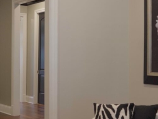 Still 2025-10-20 181133_1.2.1 The living room of a home for sale in Clayton, MO, which has been staged with two armchairs featuring black and white striped pillows.
