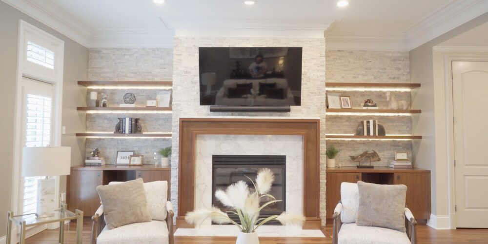 Still 2025-10-20 181133_1.7.1 Living room view of a home in Clayton, MO, showcasing the fireplace and book shelves that have been staged with elegant artwork and end pieces.