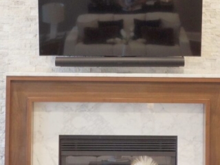 Still 2025-10-20 181133_1.7.1 Living room view of a home in Clayton, MO, showcasing the fireplace and book shelves that have been staged with elegant artwork and end pieces.