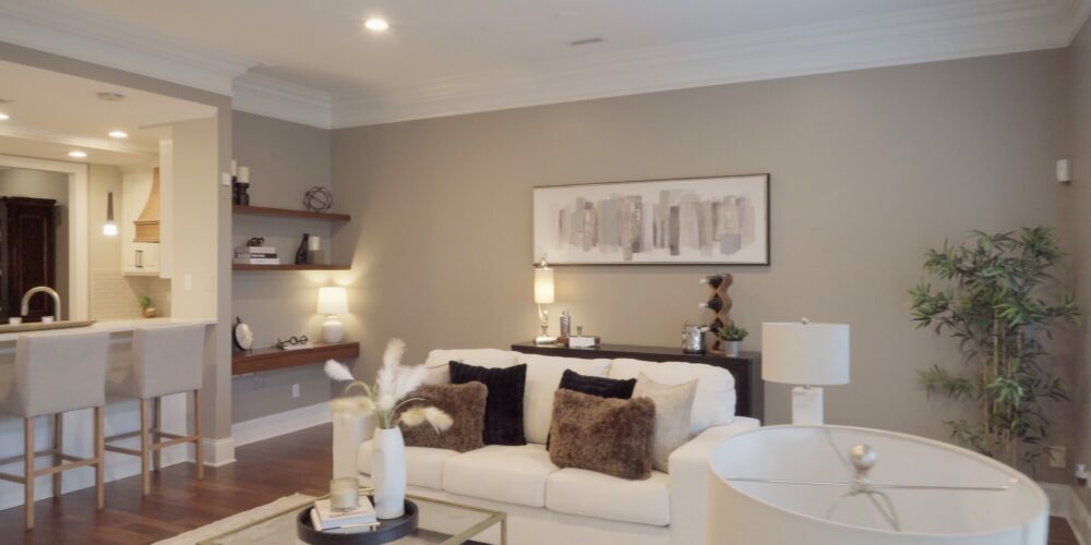 Still 2025-10-20 181133_1.8.1 Alternative view of living room in Clayton, MO, showcasing a white couch with fluffy brown fur pillows, and a beautiful art piece on the wall depicting a city skyline.